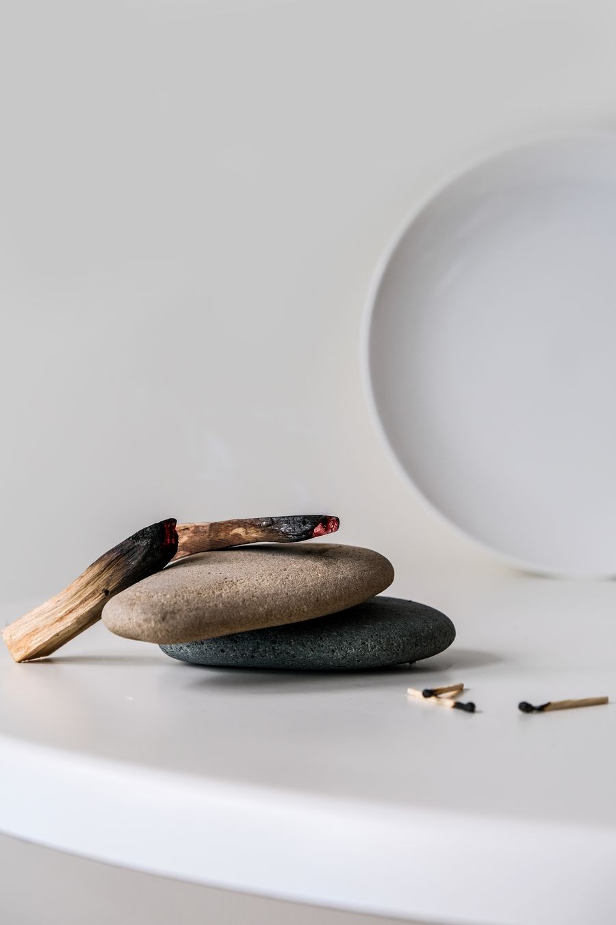 Palo santo resting on two smooth stones
